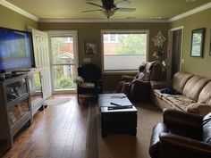 a living room filled with furniture and a flat screen tv on top of a wooden floor