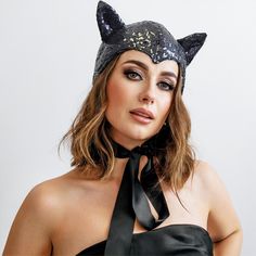 a woman wearing a black tie and cat ears on her head is posing for the camera