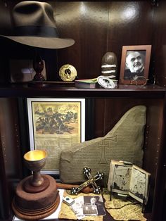 a shelf filled with books and hats on top of a wooden table next to other items