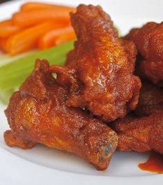 chicken wings and carrots on a white plate