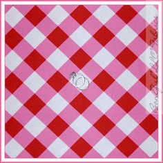 a pink and white checkered table cloth with a cat on it