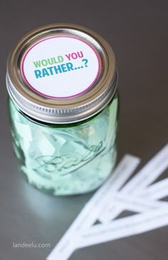 a jar filled with money sitting on top of a table next to some white cards