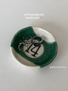 a green and white bowl with a pair of scissors in the shape of a horse