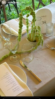 the table is set with dishes, silverware and menus for an elegant dinner