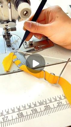 someone is using scissors to cut fabric on a sewing machine with tape and measuring tape