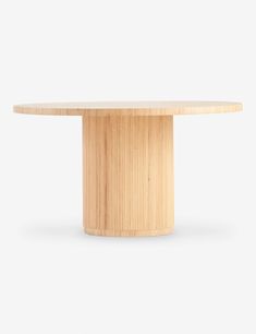 a round wooden table sitting on top of a white floor