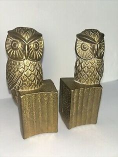 two gold owl bookends sitting next to each other