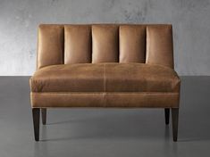 a brown leather couch sitting on top of a gray floor