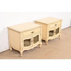 two cream colored nightstands with glass doors