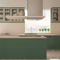 a kitchen with green cabinets and white counter tops