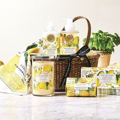 a basket filled with soaps and lotions next to a potted lemon plant