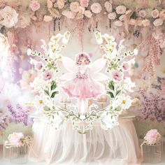 there is a pink fairy sitting on top of a table in front of flowers and other decorations