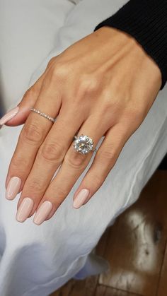 a woman's hand with a ring on it and a diamond in the middle