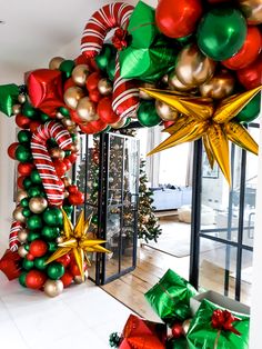 christmas decorations on display in front of a glass door with large stars and ornaments hanging from it