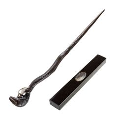 a harry potter's wand is shown next to a black box with a white background