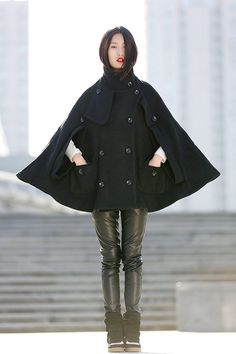 "The Cape coat is a must-have for any feminine lady wanting to turn heads. The black color will match every outfit you own so you'll find yourself wearing this again and again. The short length also makes it super easy to wear with anything. This black poncho style coat will be sheer pleasure all through the cold winter months. FEATURES Wool blend 50% wool,other fiber, nylon No lining High neckline Double breasted buttons Two pockets Oversize fit Loose fit Mini length Perfect for winter,spring,a Black Pea Coat For Cold Weather, Chic Winter Wool Cape Coat, Black Wool Poncho For Winter, Black Cape Styled As Long Coat For Fall, Black Long Cape For Fall, Black Cape For Fall, Elegant Black Cape Outerwear, Chic Black Wool Cape, Winter Poncho With Cape Sleeves