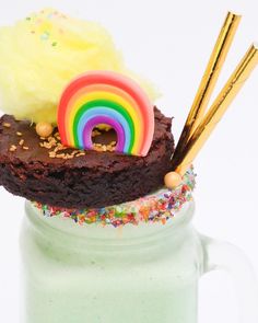 there is a chocolate cake in a jar with sprinkles and rainbow decorations