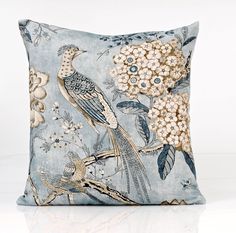 a blue pillow with birds and flowers on it