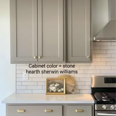 a kitchen with gray cabinets and white subway backsplash