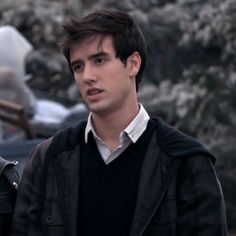 a young man standing in front of a car