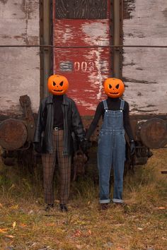 two people in overalls with pumpkin heads on their faces