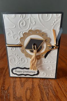 a graduation card with a tasseled cap on the front and black ribbon around the edges