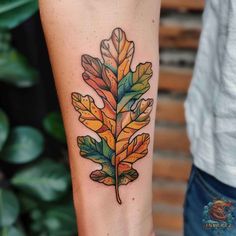 a colorful leaf tattoo on the arm