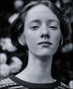 a black and white photo of a woman with freckled hair