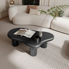 a black coffee table sitting on top of a carpeted floor next to a white couch