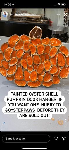 a pile of oranges sitting on top of a counter next to a sign that says, painted oyster shell pumpkin dog hanger if you want one hurry to