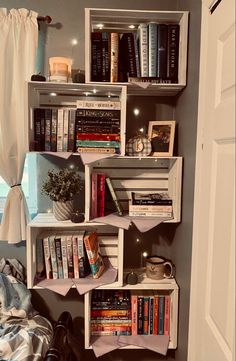 a bookshelf filled with lots of books next to a window in a room