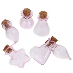 small pink glass bottles with corks and star shaped tops on white background, set of four