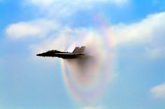 a jet flying through the air with a rainbow in the sky behind it that says sonic boom just got 20 percent cooler