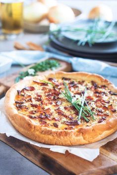 a pizza sitting on top of a wooden cutting board next to other food and utensils