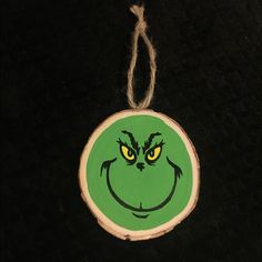 a wooden ornament with a grin face painted on it