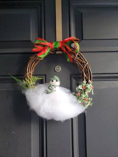 a wreath on the front door decorated with white fluffy balls and red bows