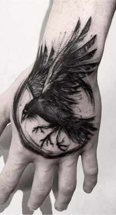 a hand with a bird tattoo on it