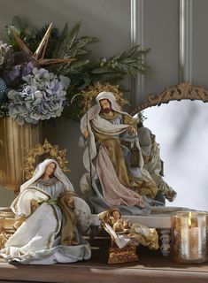 a statue of the virgin mary and baby jesus in front of a mirror with candles