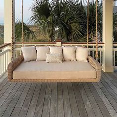 a porch swing with pillows on it