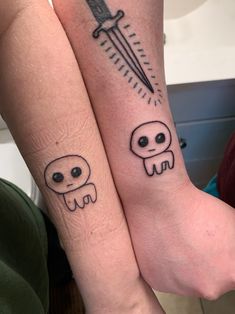 two people with matching tattoos on their arms, one has a knife and the other has a skull