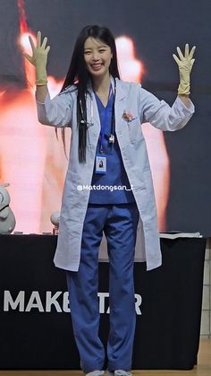 a woman standing on top of a wooden floor in front of a large screen with her hands up