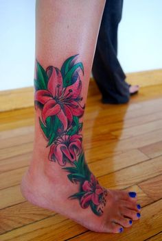 a woman's foot with flowers and leaves on the bottom part of her leg