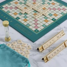 scrabble tiles, letters and other items on a marble counter top with blue velvet drawstring