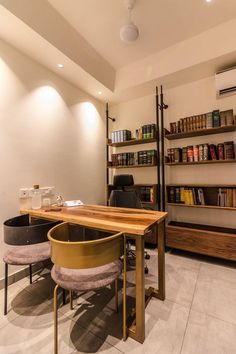 a room with shelves, chairs and a desk in the middle of it is lit by recessed lights