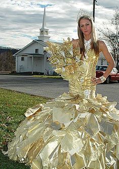 a woman in a gold dress standing on the grass