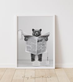 a black and white photo of a bear reading a newspaper