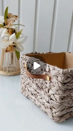 a basket sitting on top of a table next to a vase