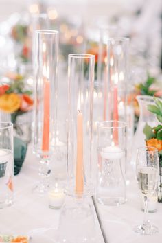 the table is set with candles and clear vases