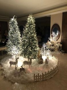 christmas trees are lit up in the middle of a room with snow on the ground