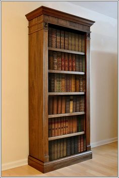 an old wooden bookcase with many books on it